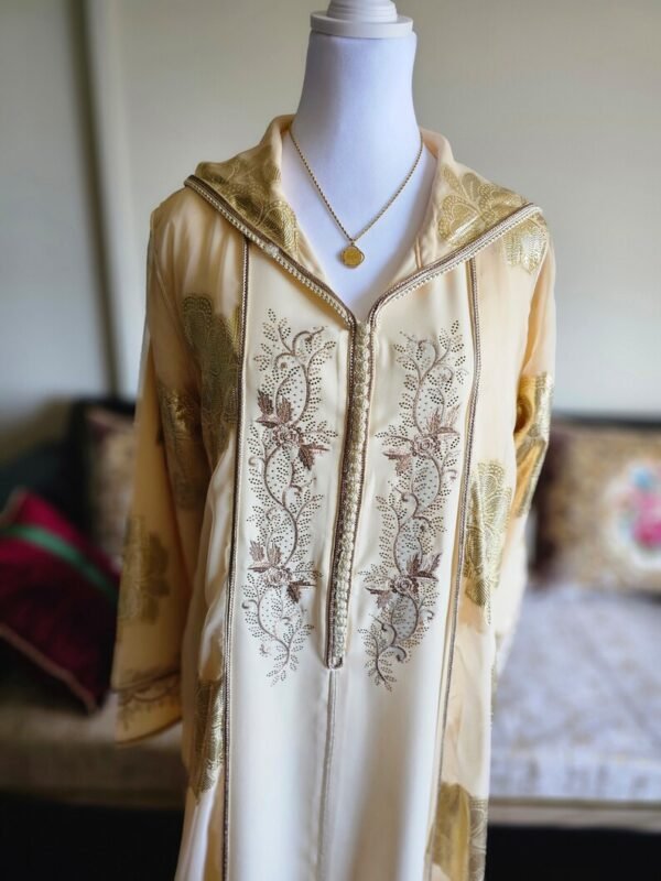 Beige djellaba featuring delicate brown embroidery with sophisticated handcrafted traditional accents.